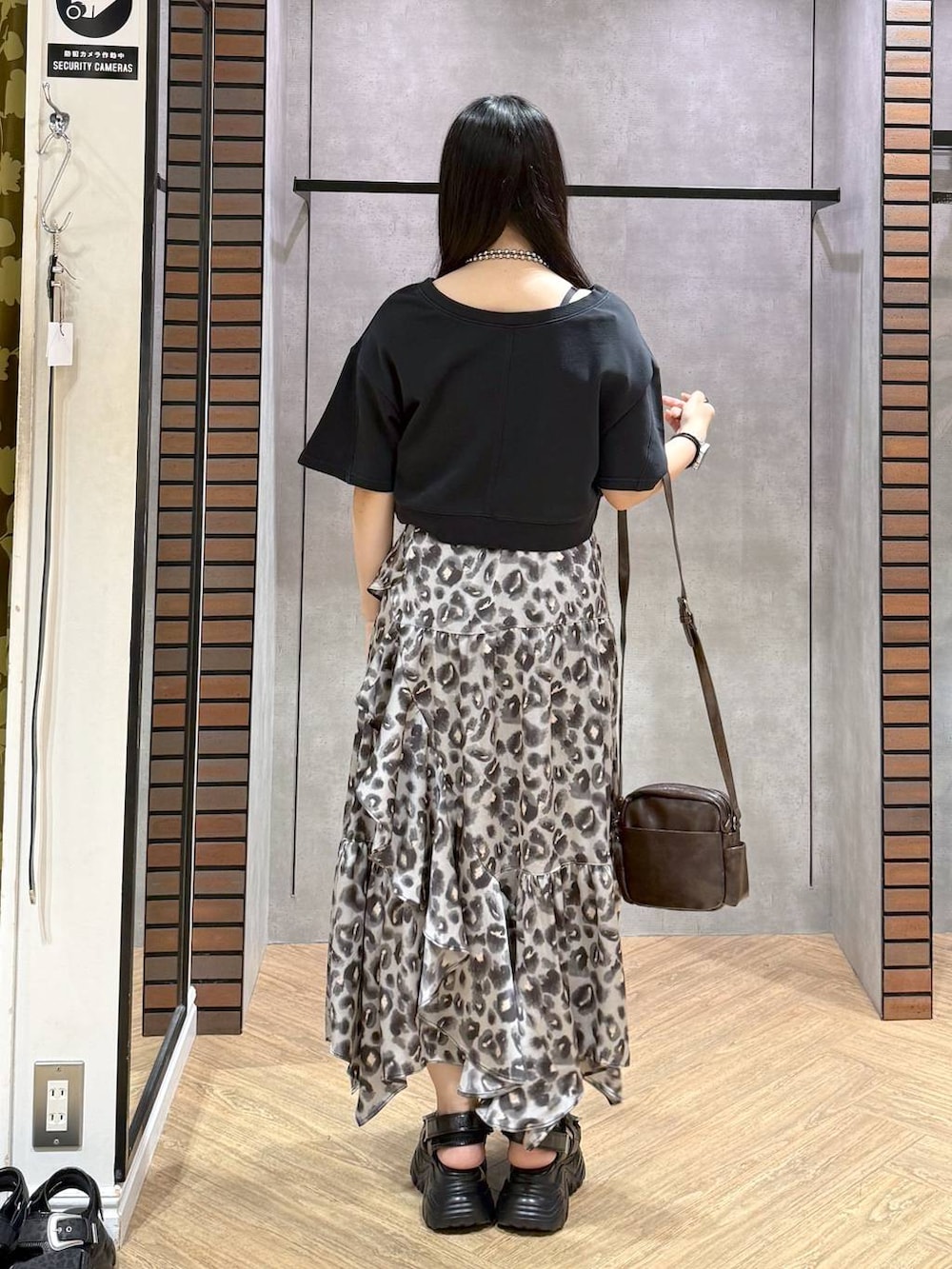 ブラック系のスウェット、その他のスカート、ブラウン系のショルダーバッグを着用したレディースの夏コーディネートの3枚目の写真