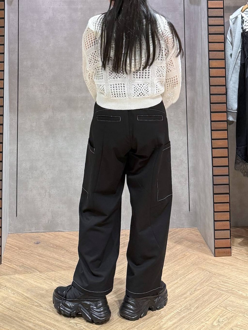 ブラック系のスニーカー、ブラウン系のショルダーバッグ、ブルー系のタンクトップを着用したレディースの春コーディネートの2枚目の写真