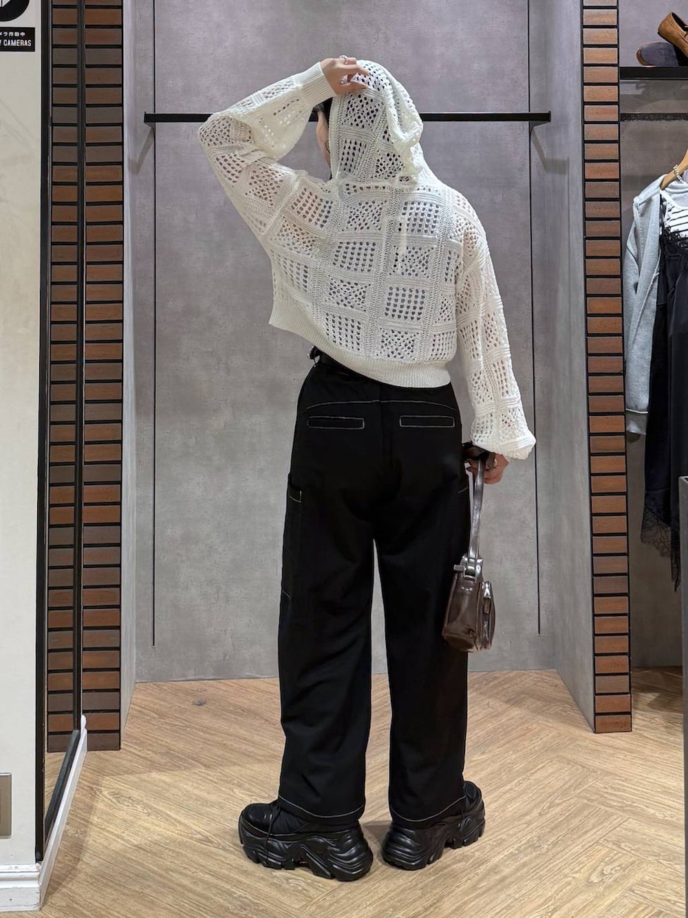 ブラック系のスニーカー、ブラウン系のショルダーバッグ、ブルー系のタンクトップを着用したレディースの春コーディネートの6枚目の写真