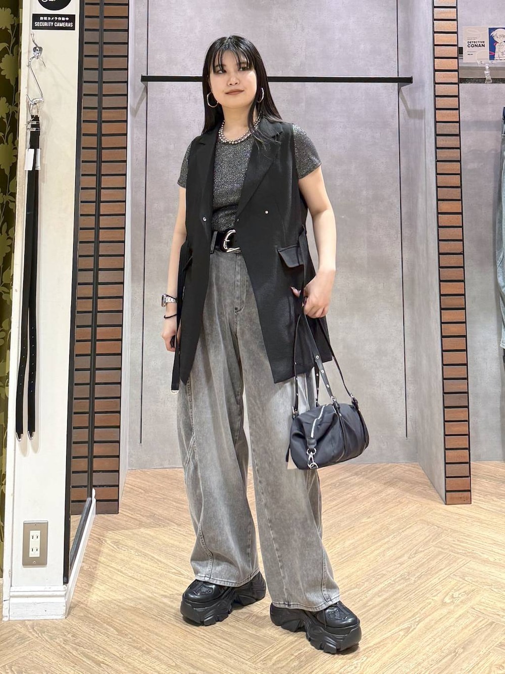 ブラック系のスニーカー、ブラック系のデニムパンツ、ブラック系のテーラードジャケットを着用したレディースの夏コーディネートの4枚目の写真
