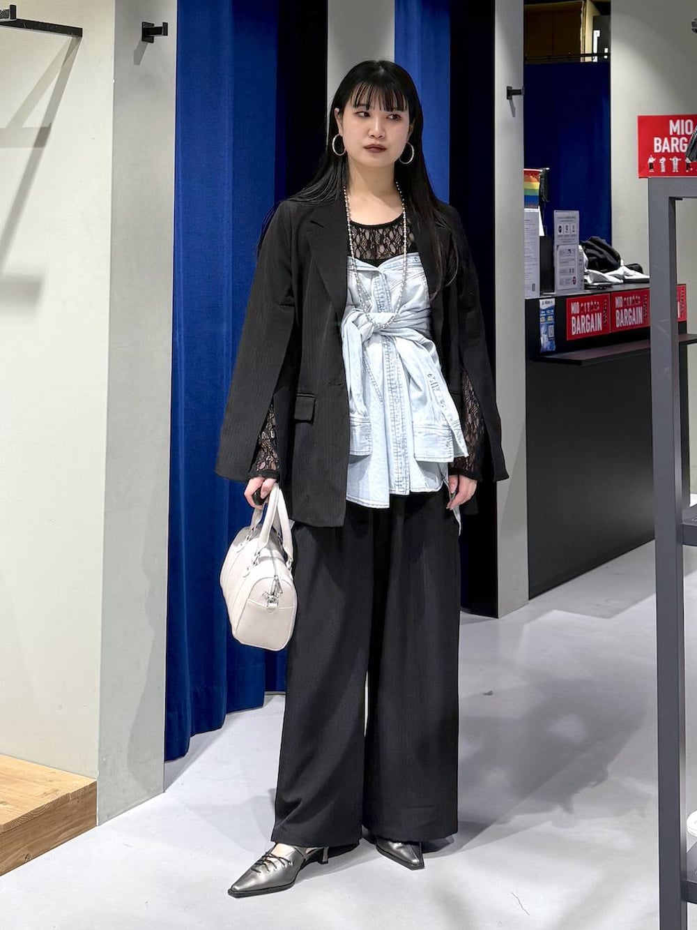 ブラック系のTシャツ/カットソー、ブラック系のテーラードジャケット、ブラック系のデニムパンツを着用したレディースの冬コーディネートの6枚目の写真