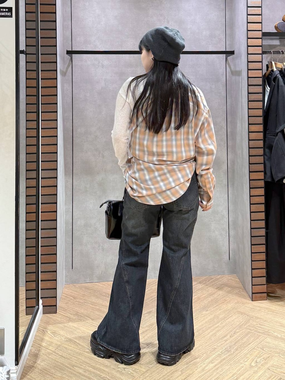 ブラック系のスニーカー、ブルー系のデニムパンツ、ブラック系のショルダーバッグを着用したレディースの春コーディネートの5枚目の写真