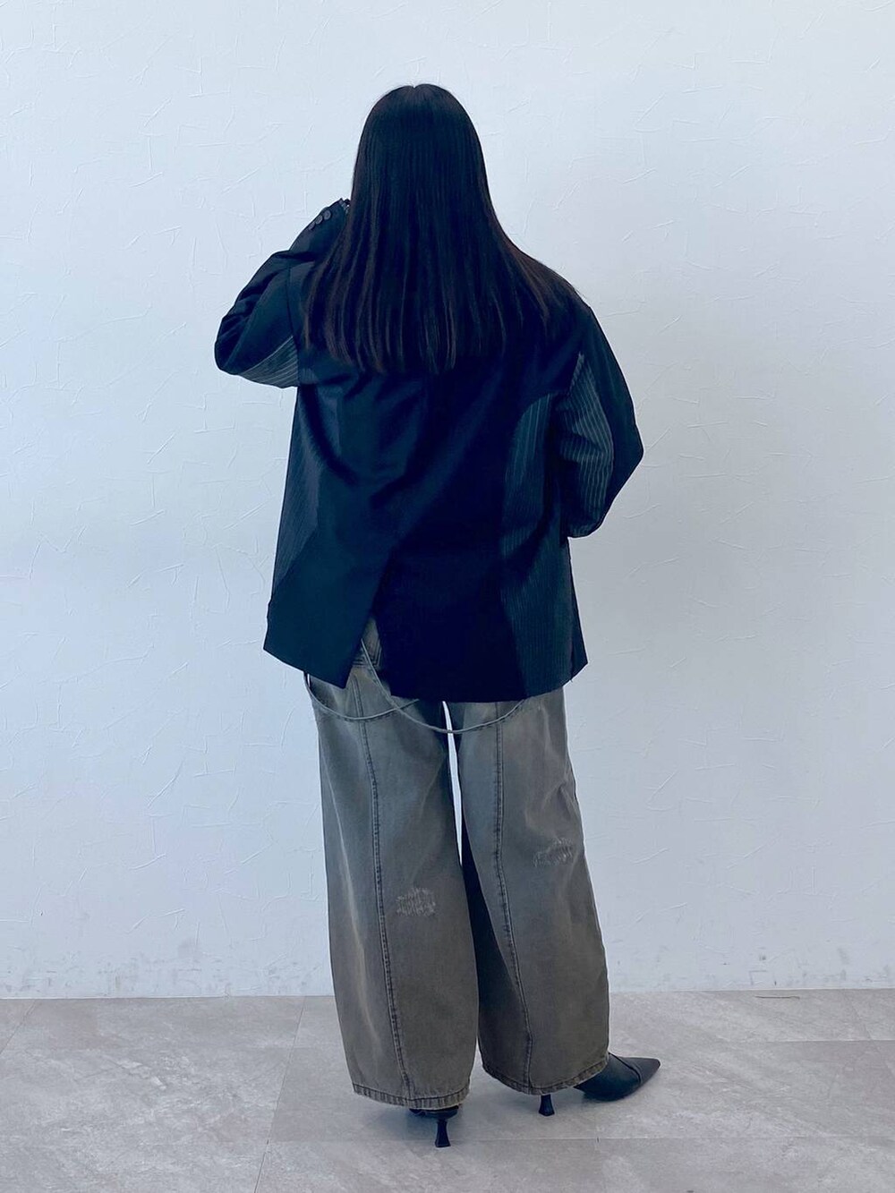 ブラック系のテーラードジャケット、ホワイト系のポロシャツを着用したレディースの冬コーディネートの5枚目の写真