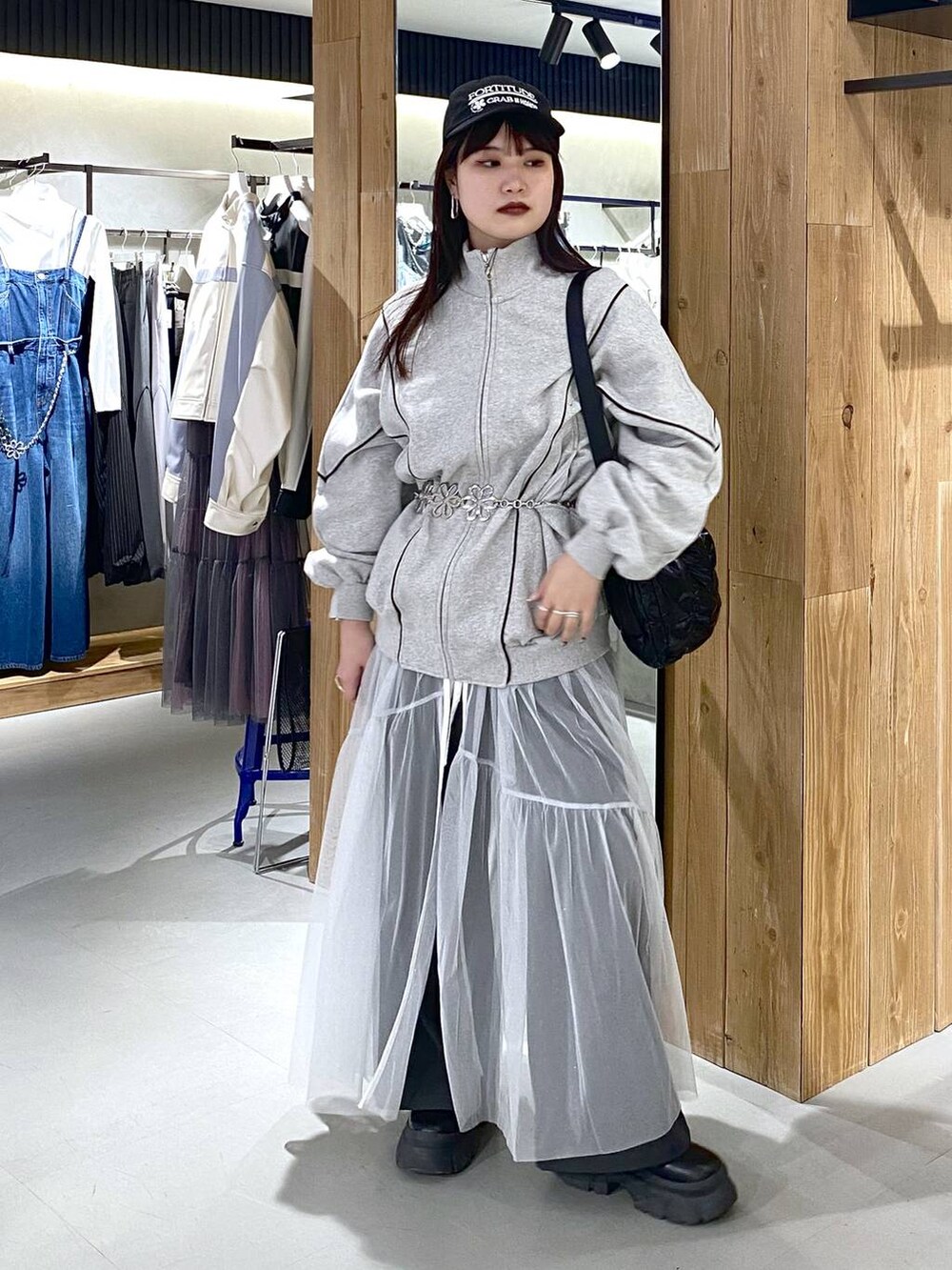 ブラック系のショルダーバッグ、グレー系のスウェット、ホワイト系のワンピースを着用したレディースの春コーディネートの3枚目の写真