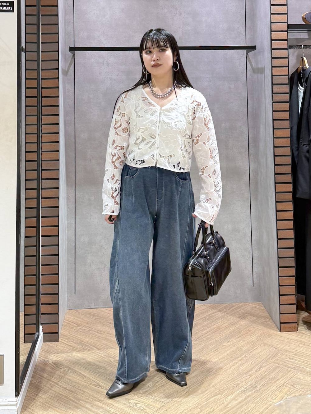 ブラック系のショルダーバッグ、ホワイト系のタンクトップ、ブラウン系のサンダルを着用したレディースの春コーディネートの2枚目の写真