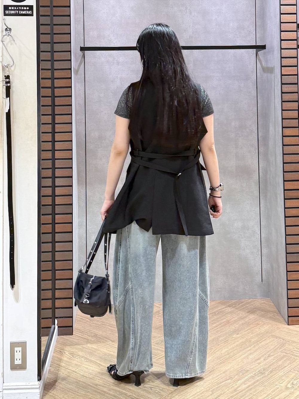 ブルー系のデニムパンツ、ブラック系のサンダル、ブラック系のテーラードジャケットを着用したレディースの夏コーディネートの3枚目の写真