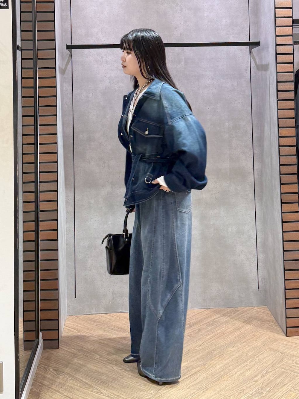 ブルー系のブルゾン、グレー系のショルダーバッグ、ホワイト系のタンクトップを着用したレディースの春コーディネートの7枚目の写真