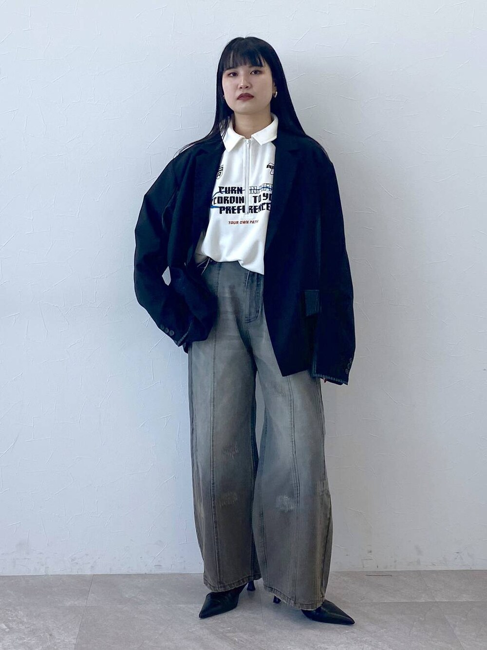 ブラック系のテーラードジャケット、ホワイト系のポロシャツを着用したレディースの冬コーディネートの3枚目の写真