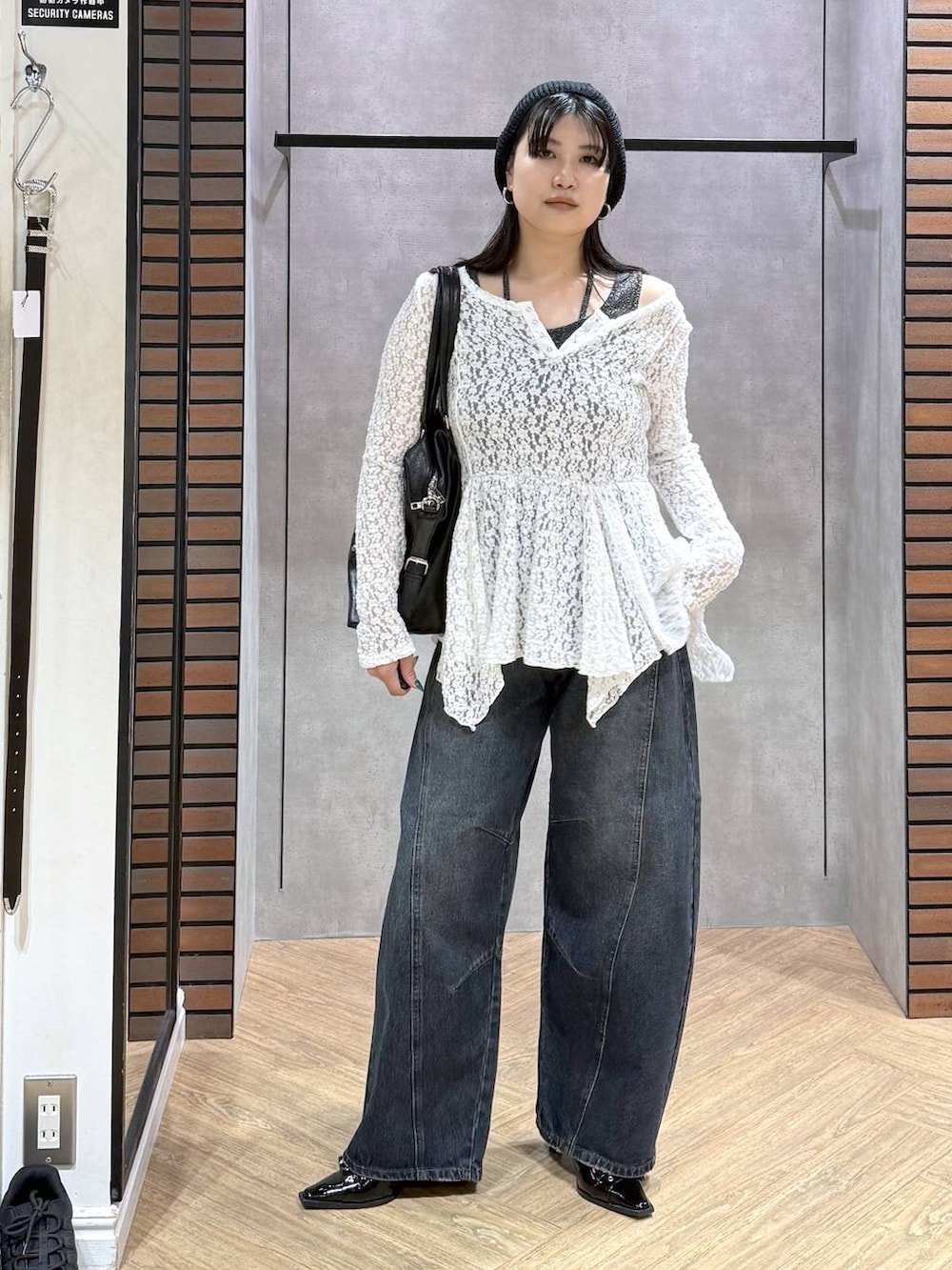 ブラック系のサンダル、ブラック系のボストンバッグ、ブルー系のデニムパンツを着用したレディースの夏コーディネートの6枚目の写真