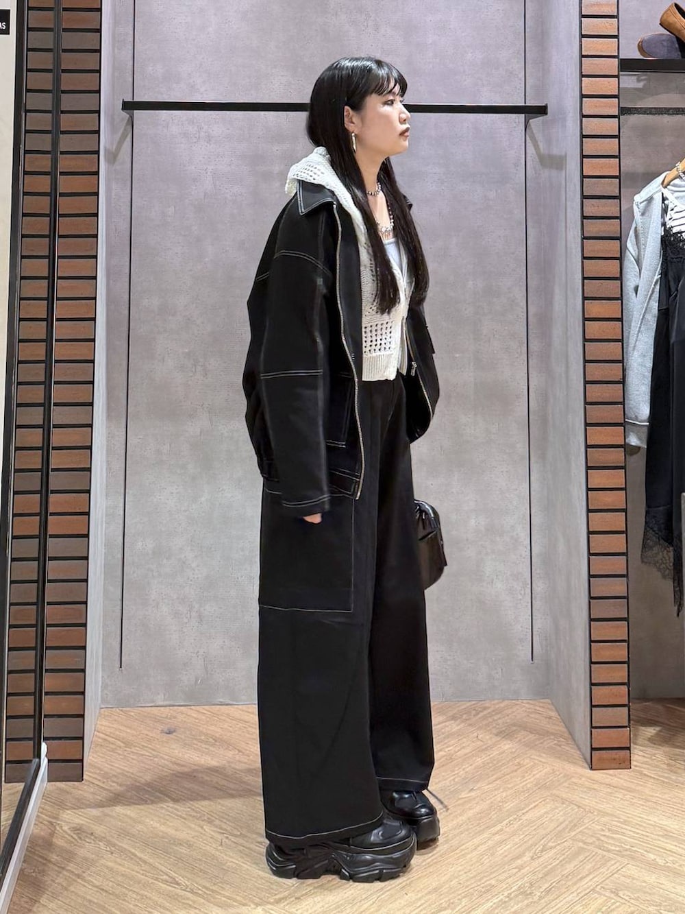 ブラック系のスニーカー、ブラック系のショルダーバッグ、ブルー系のタンクトップを着用したレディースの春コーディネートの7枚目の写真