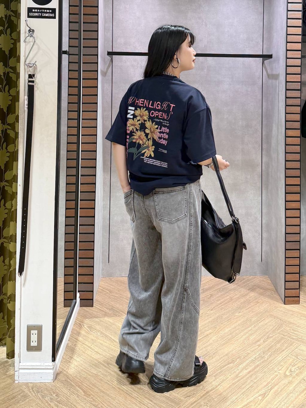 ブラック系のショルダーバッグ、ブラック系のデニムパンツ、ブラック系のサンダルを着用したレディースの夏コーディネートの3枚目の写真