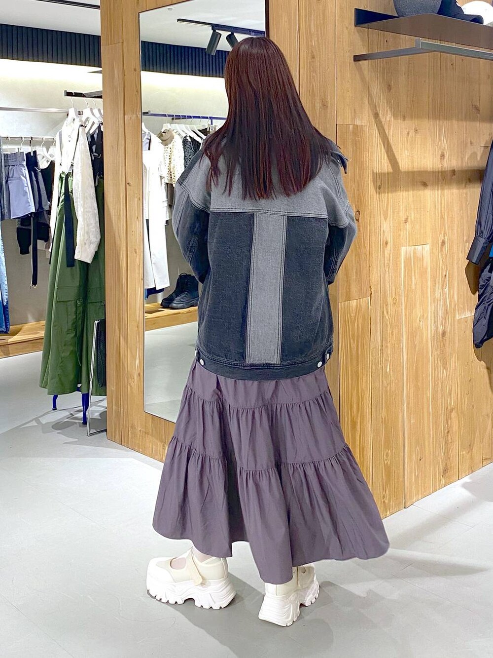 ブルー系のタンクトップ、ブラック系のデニムジャケット、ブラック系のボストンバッグを着用したレディースの春コーディネートの3枚目の写真