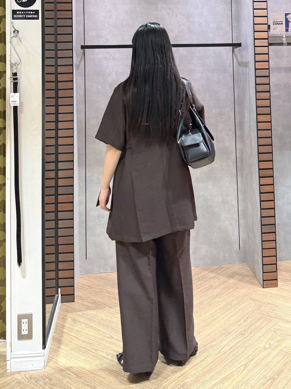 ホワイト系のタンクトップ、ブラック系のサンダル、ブラウン系のスラックスを着用したレディースの夏コーディネートの5枚目の写真