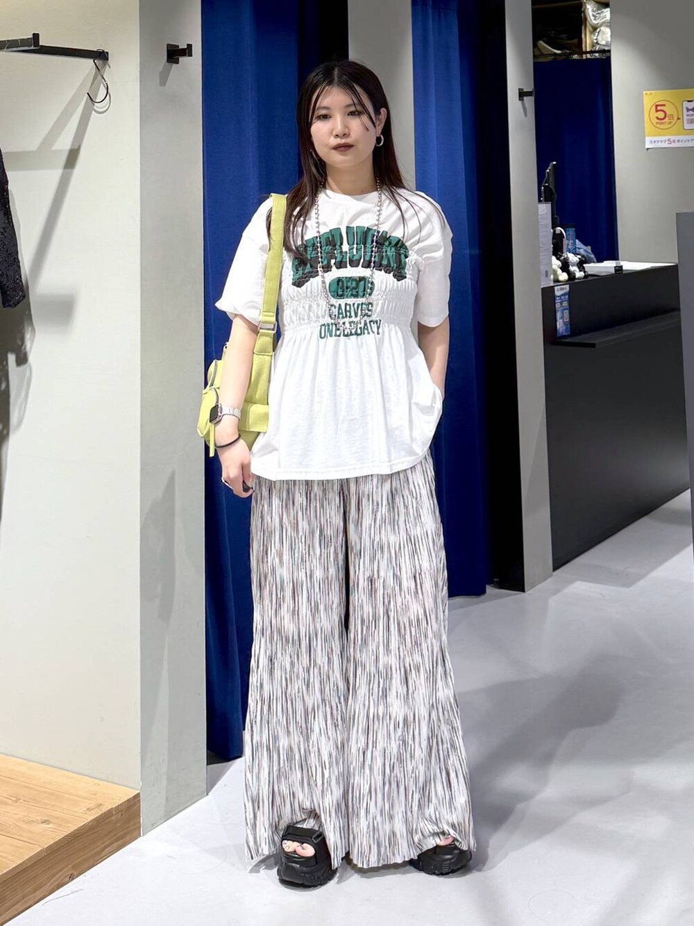 ブラック系のサンダル、グリーン系のショルダーバッグ、ホワイト系のその他パンツを着用したレディースの夏コーディネートの2枚目の写真