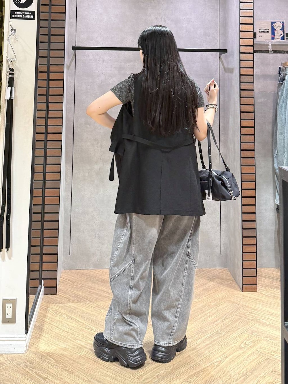 ブラック系のスニーカー、ブラック系のデニムパンツ、ブラック系のテーラードジャケットを着用したレディースの夏コーディネートの5枚目の写真