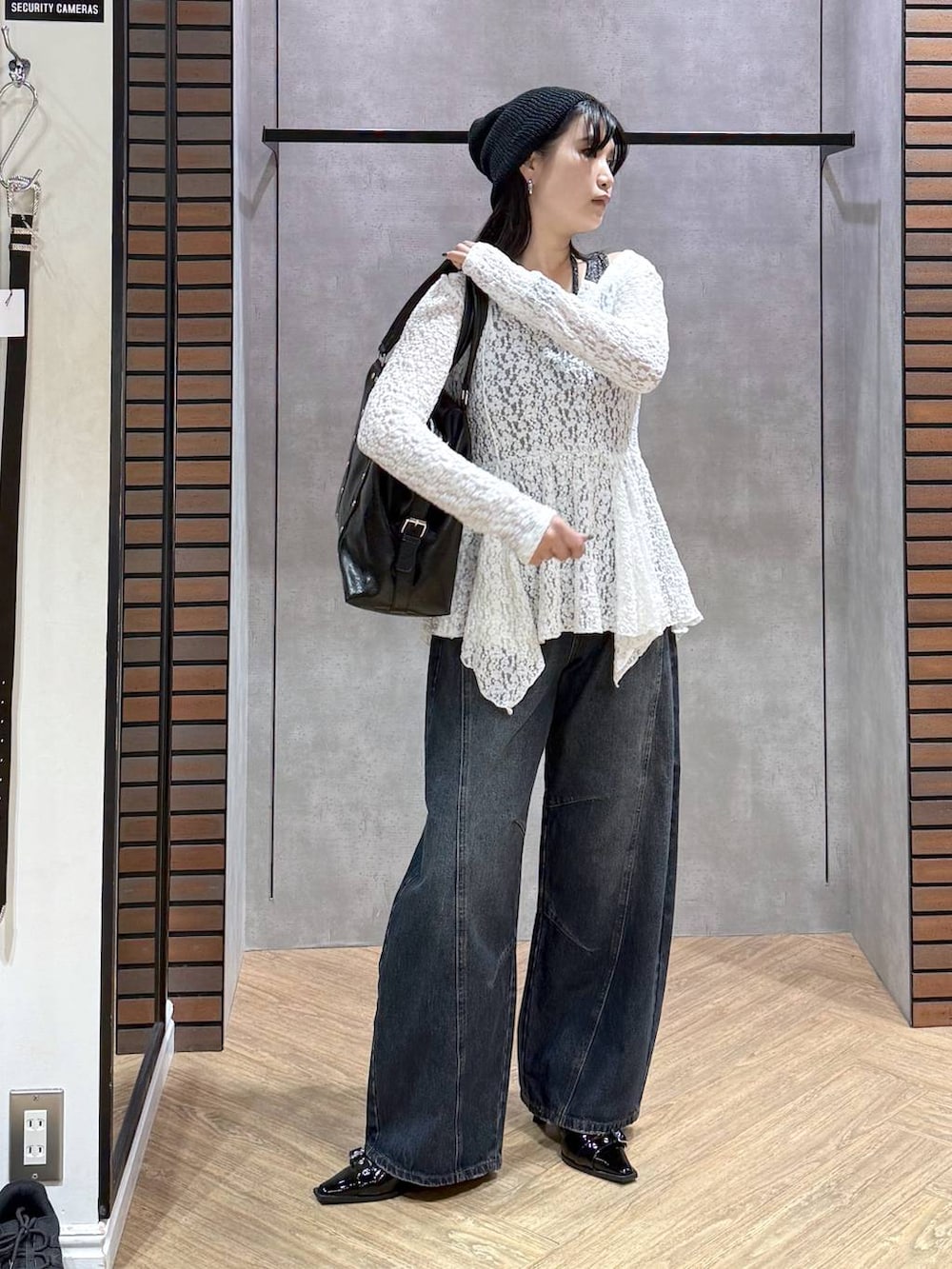 ブラック系のサンダル、ブラック系のボストンバッグ、ブルー系のデニムパンツを着用したレディースの夏コーディネートの3枚目の写真