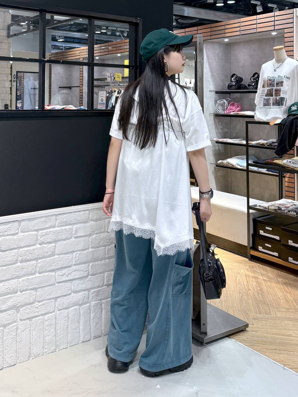ブラック系のショルダーバッグ、ブラック系のサンダル、ホワイト系のTシャツ/カットソーを着用したレディースの春コーディネートの4枚目の写真