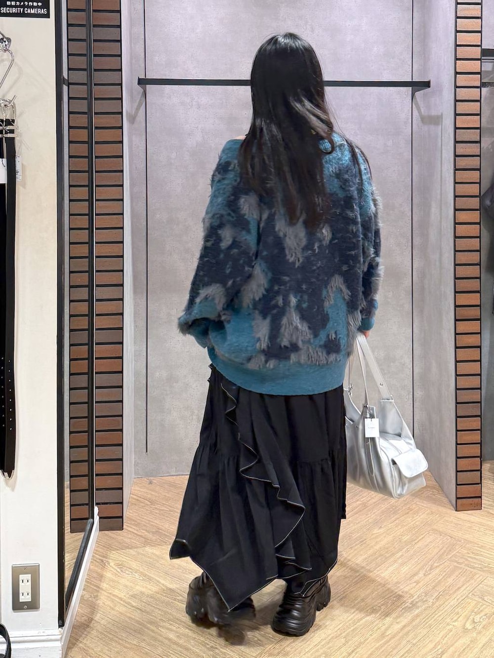 ブラック系のスニーカー、ブルー系のカーディガン/ボレロ、ブラック系のスカートを着用したレディースの夏コーディネートの3枚目の写真