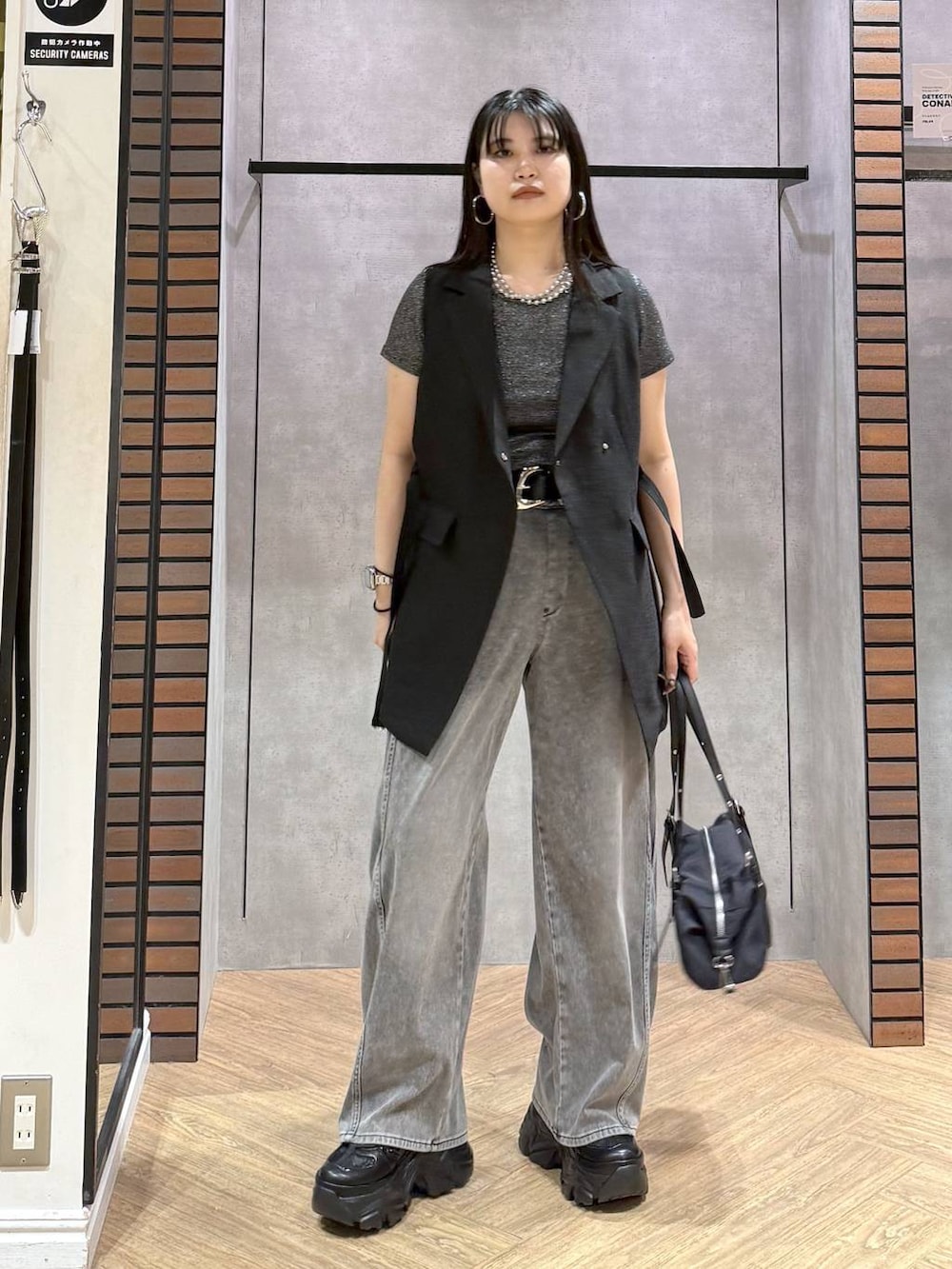 ブラック系のスニーカー、ブラック系のデニムパンツ、ブラック系のテーラードジャケットを着用したレディースの夏コーディネートの3枚目の写真