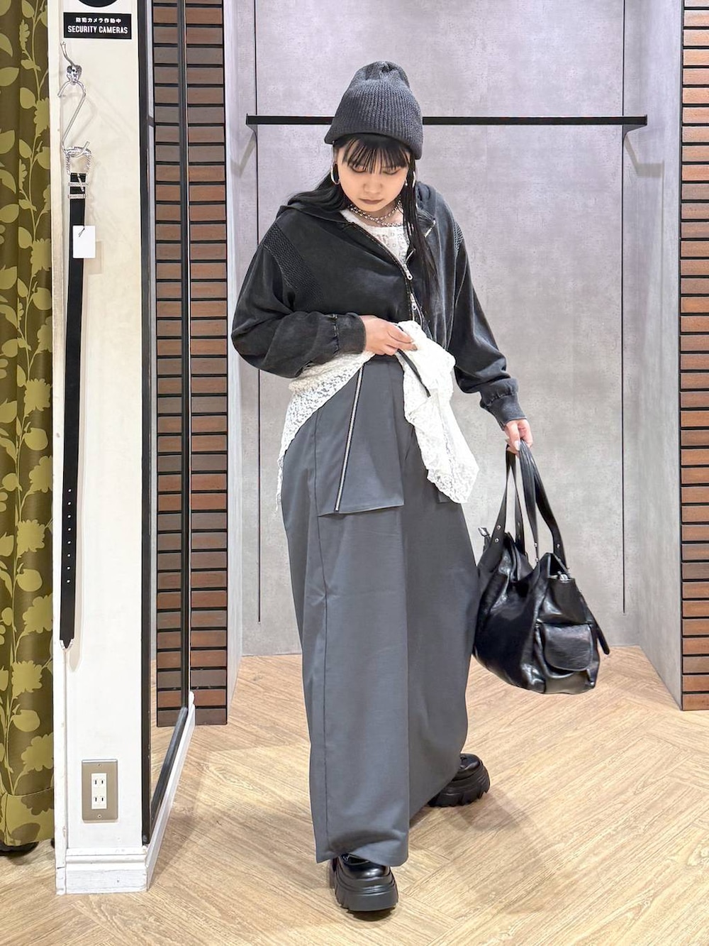 ブラック系のブーツ、グレー系のパーカー、ホワイト系のチュニックを着用したレディースの秋コーディネートの2枚目の写真