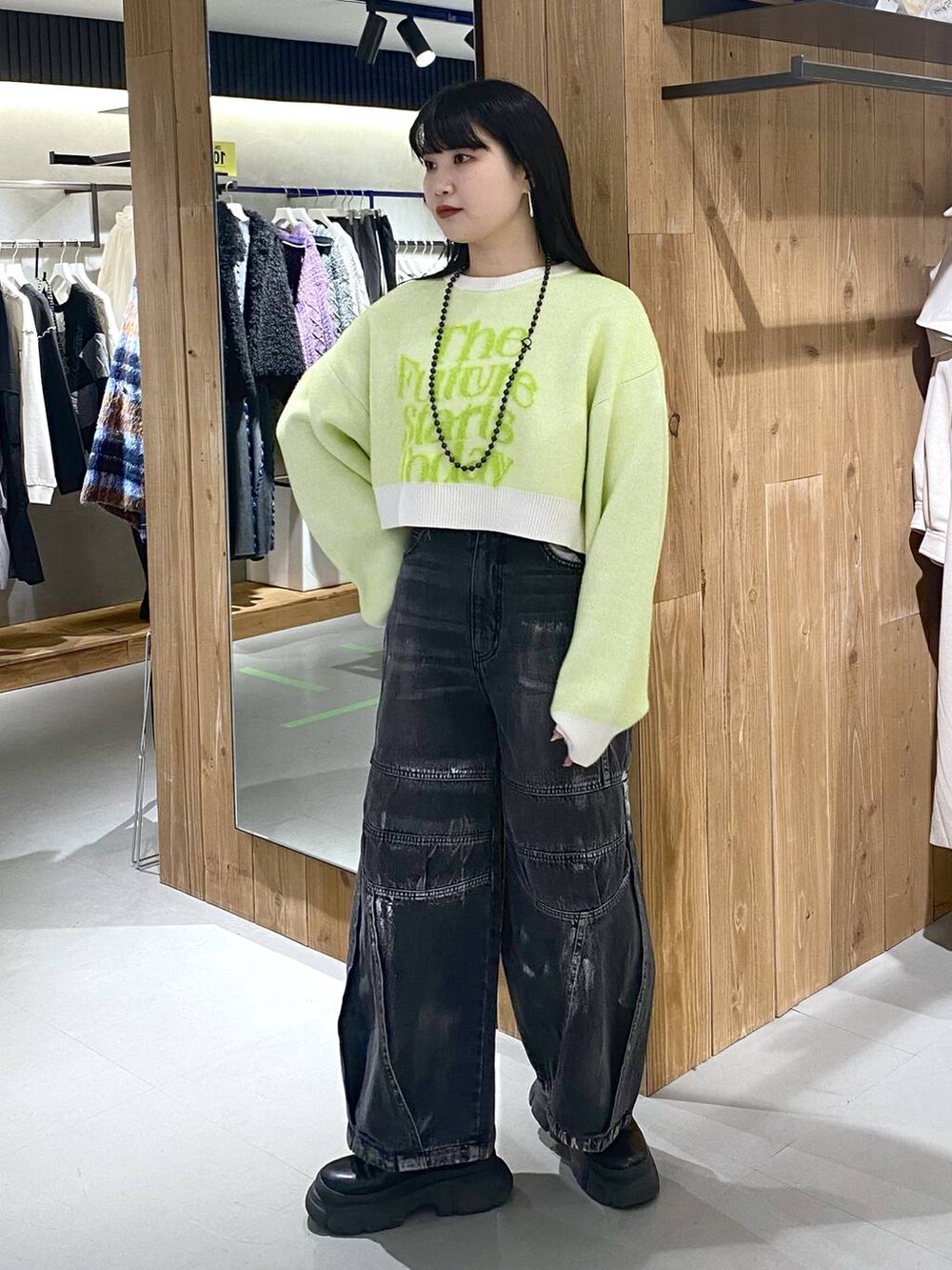 ブラック系のブーツ、ホワイト系のニット/セーター、ブラック系のショルダーバッグを着用したレディースの冬コーディネートの5枚目の写真