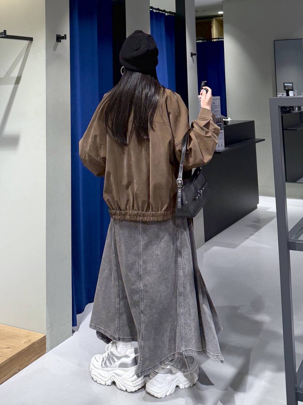 ホワイト系のスニーカー、ブラック系のハンドバッグ、ホワイト系のニット/セーターを着用したレディースの春コーディネートの8枚目の写真