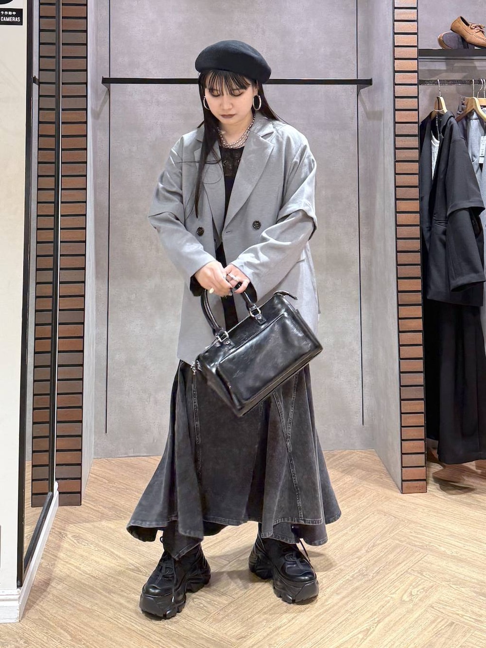 ブラック系のスニーカー、ブラック系のキャミソール、ブラック系のショルダーバッグを着用したレディースの春コーディネートの6枚目の写真