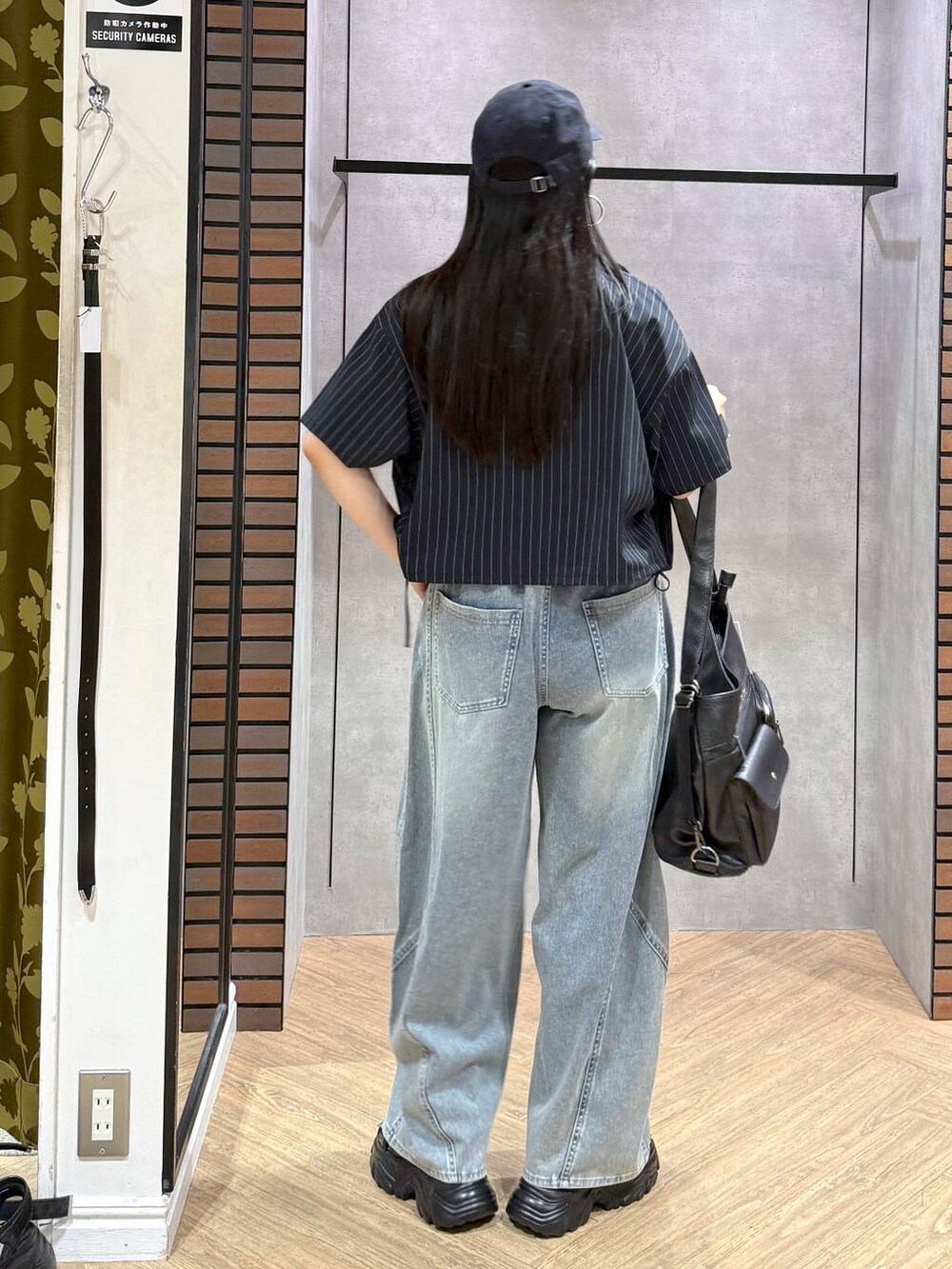 ホワイト系のタンクトップ、ブラック系のショルダーバッグ、ブルー系のデニムパンツを着用したレディースの夏コーディネートの6枚目の写真
