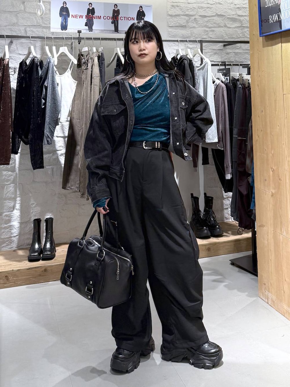 ブラック系のカーゴパンツ、ブラック系のデニムジャケット、ブラック系のスニーカーを着用したレディースの秋コーディネートの3枚目の写真