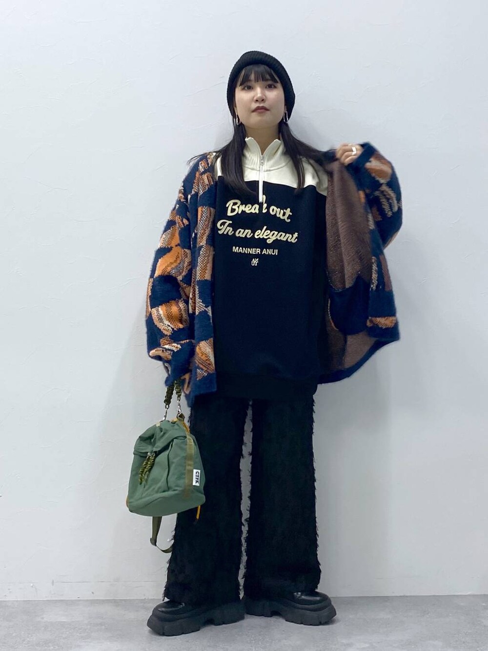 ブラック系のブーツ、ブルー系のニット/セーター、ブラック系のスラックスを着用したレディースの冬コーディネートの6枚目の写真