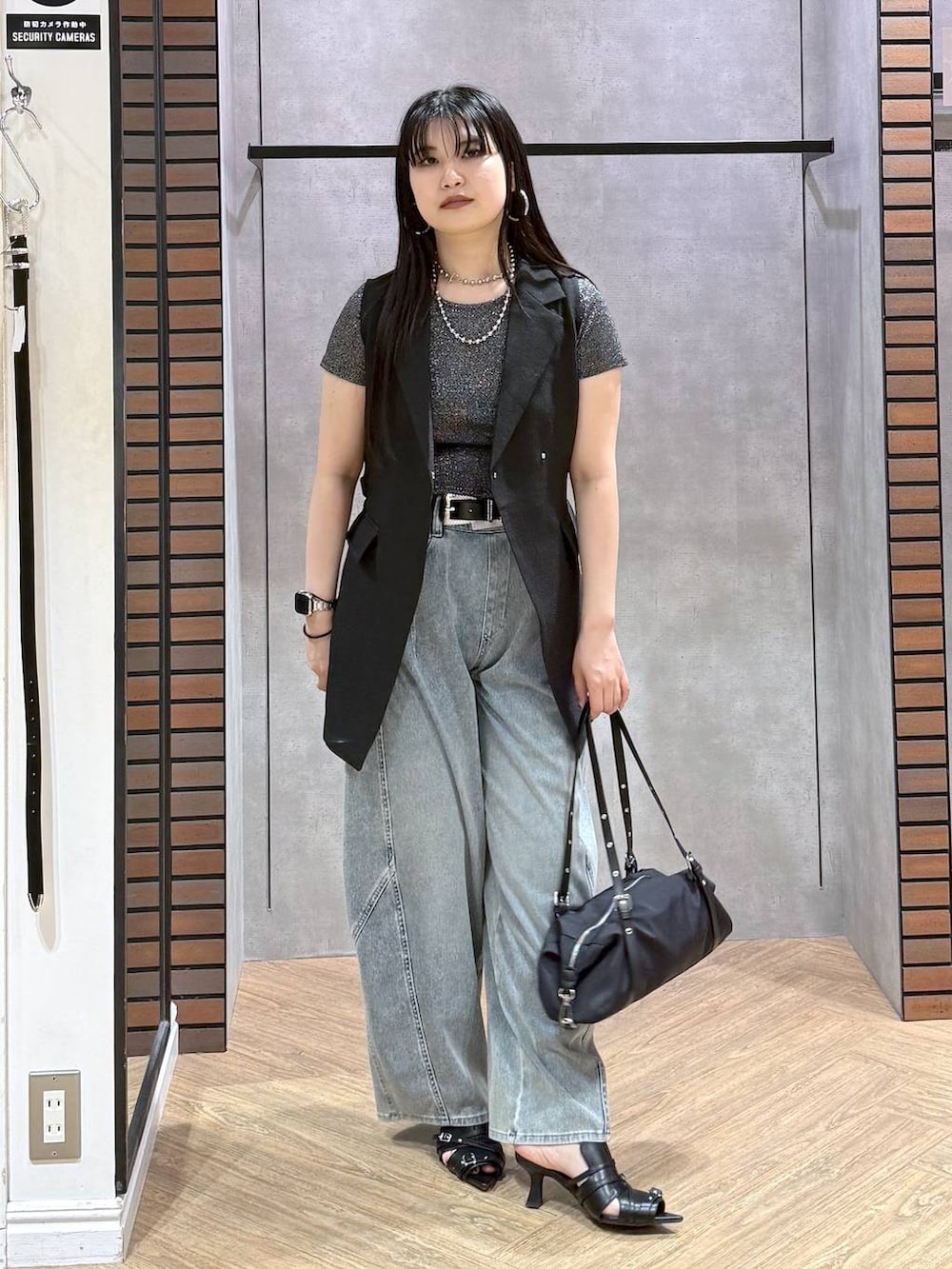 ブルー系のデニムパンツ、ブラック系のサンダル、ブラック系のテーラードジャケットを着用したレディースの夏コーディネートの5枚目の写真