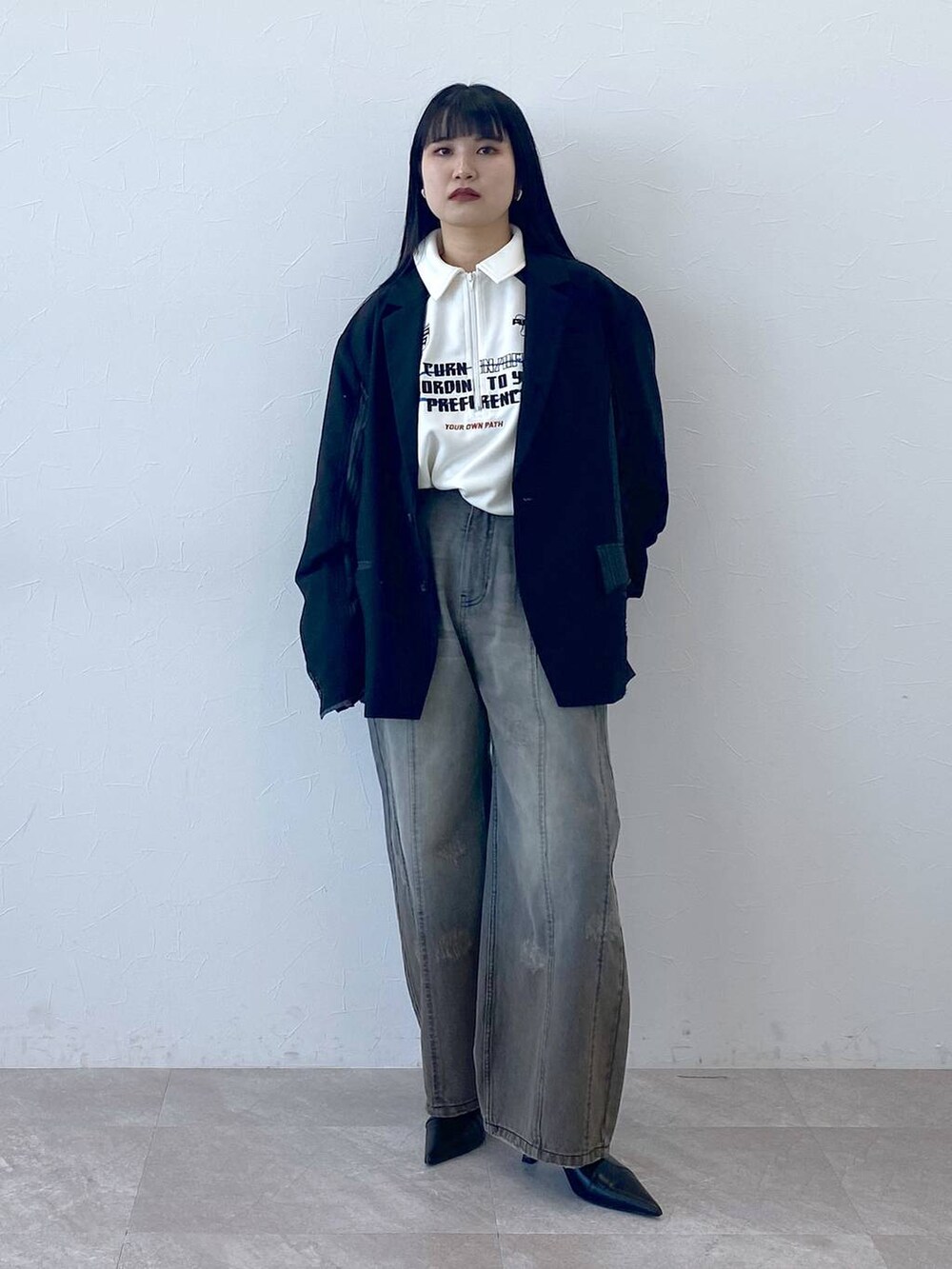 ブラック系のテーラードジャケット、ホワイト系のポロシャツを着用したレディースの冬コーディネートの7枚目の写真