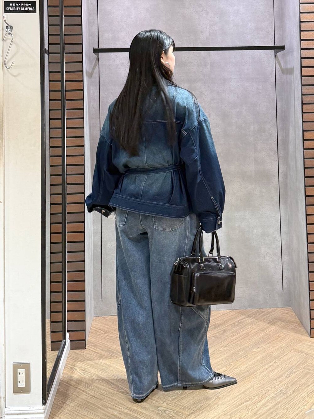 ブルー系のブルゾン、グレー系のショルダーバッグ、ホワイト系のタンクトップを着用したレディースの春コーディネートの4枚目の写真