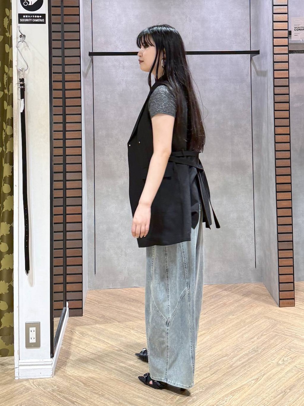 ブルー系のデニムパンツ、ブラック系のサンダル、ブラック系のテーラードジャケットを着用したレディースの夏コーディネートの2枚目の写真
