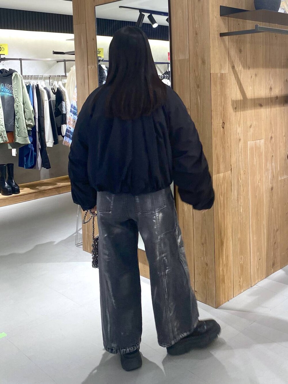 ブラック系のブーツ、ホワイト系のニット/セーター、ブラック系のショルダーバッグを着用したレディースの冬コーディネートの8枚目の写真