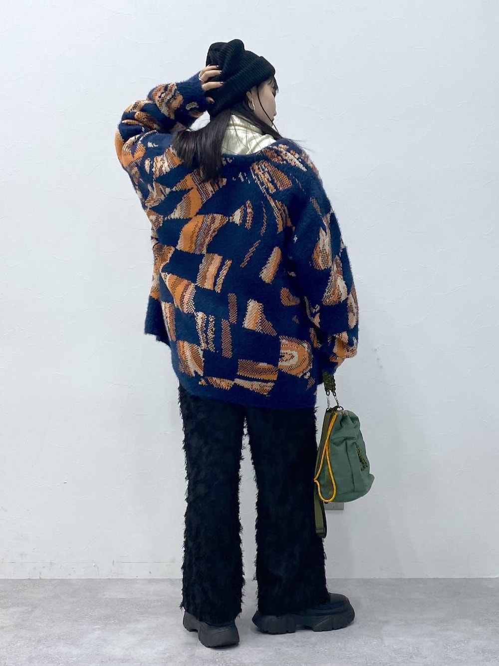 ブラック系のブーツ、ブルー系のニット/セーター、ブラック系のスラックスを着用したレディースの冬コーディネートの3枚目の写真