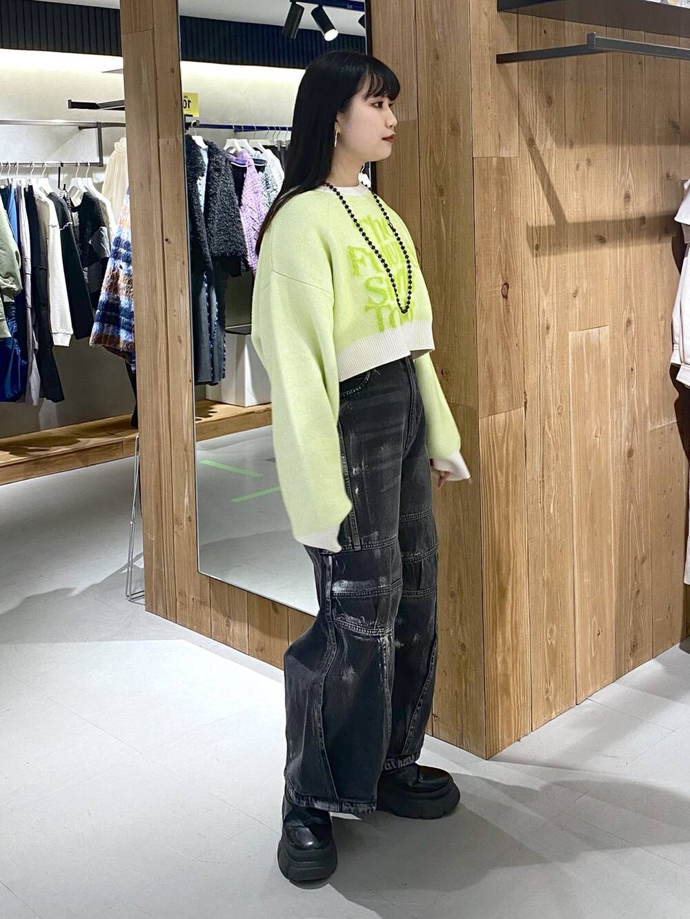 ブラック系のブーツ、ホワイト系のニット/セーター、ブラック系のショルダーバッグを着用したレディースの冬コーディネートの3枚目の写真