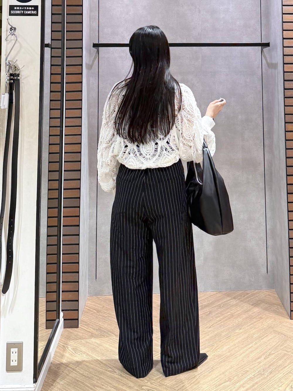 ブラック系のキャミソール、ホワイト系のカーディガン/ボレロ、ブラック系のトートバッグを着用したレディースの春コーディネートの5枚目の写真