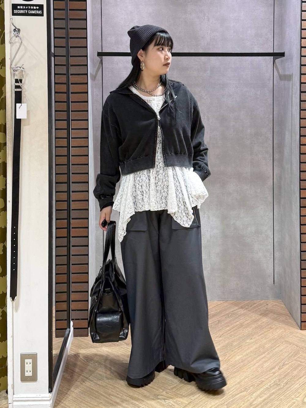 ブラック系のブーツ、グレー系のパーカー、ホワイト系のチュニックを着用したレディースの秋コーディネートの5枚目の写真