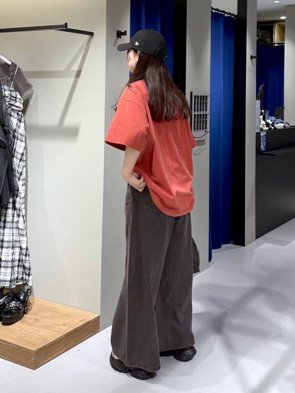 ブラック系のデニムパンツ、ブラック系のボストンバッグ、グレー系のサンダルを着用したレディースの夏コーディネートの3枚目の写真