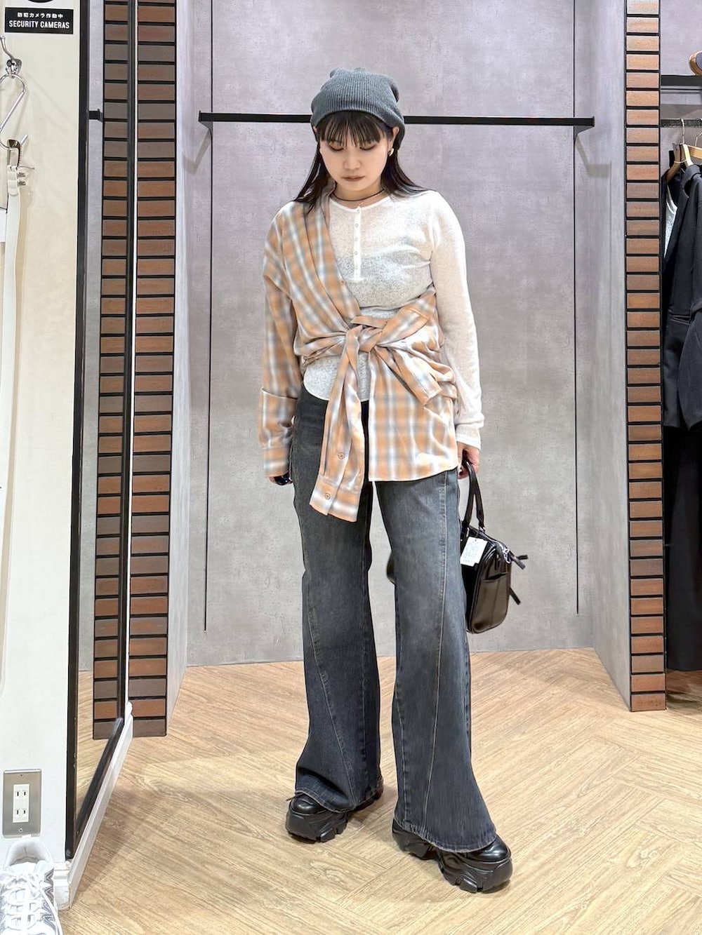 ブラック系のスニーカー、ブルー系のデニムパンツ、ブラック系のショルダーバッグを着用したレディースの春コーディネートの6枚目の写真