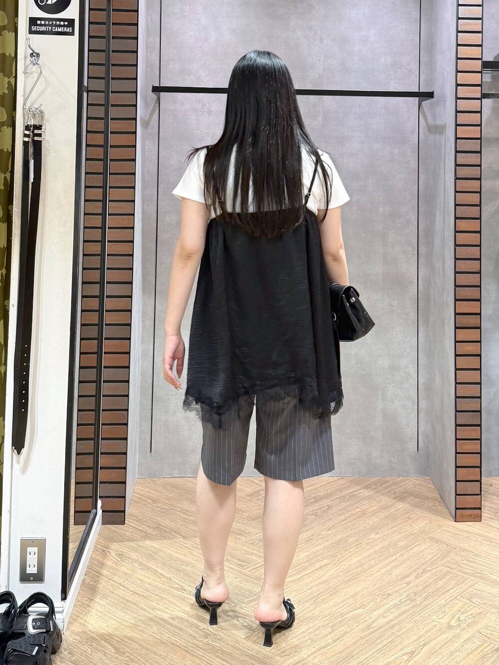 ブラック系のサンダル、ホワイト系のTシャツ/カットソー、ブラック系のキャミソールを着用したレディースの夏コーディネートの5枚目の写真
