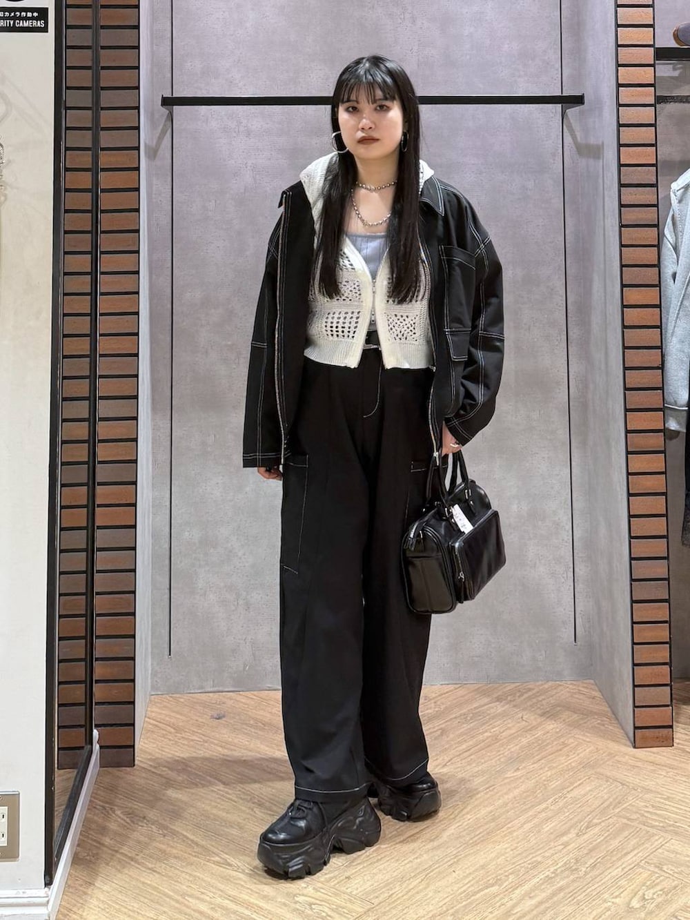 ブラック系のスニーカー、ブラック系のショルダーバッグ、ブルー系のタンクトップを着用したレディースの春コーディネートの6枚目の写真