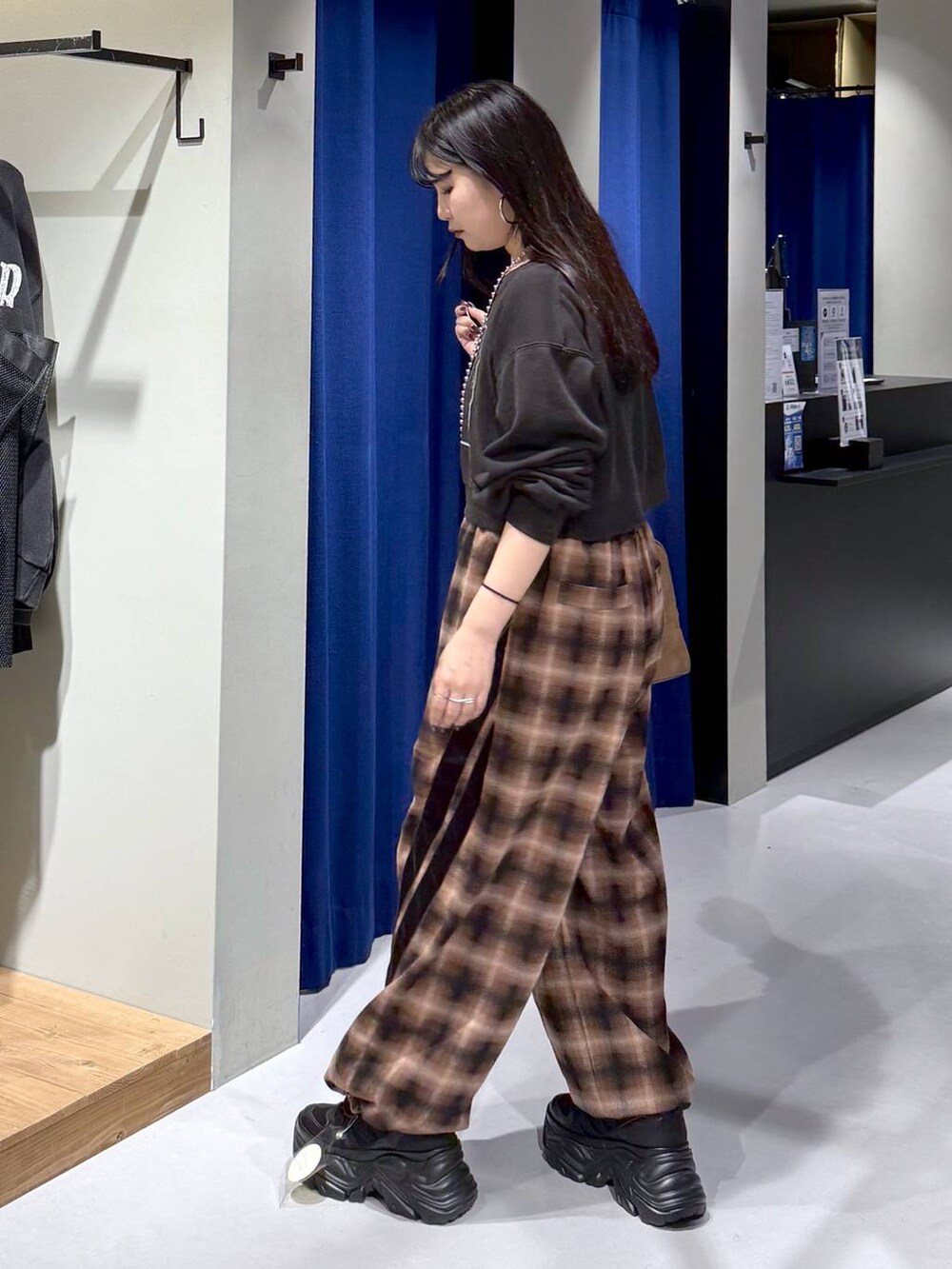 ブラック系のスニーカー、イエロー系のボストンバッグ、ブラウン系のスラックスを着用したレディースの秋コーディネートの4枚目の写真