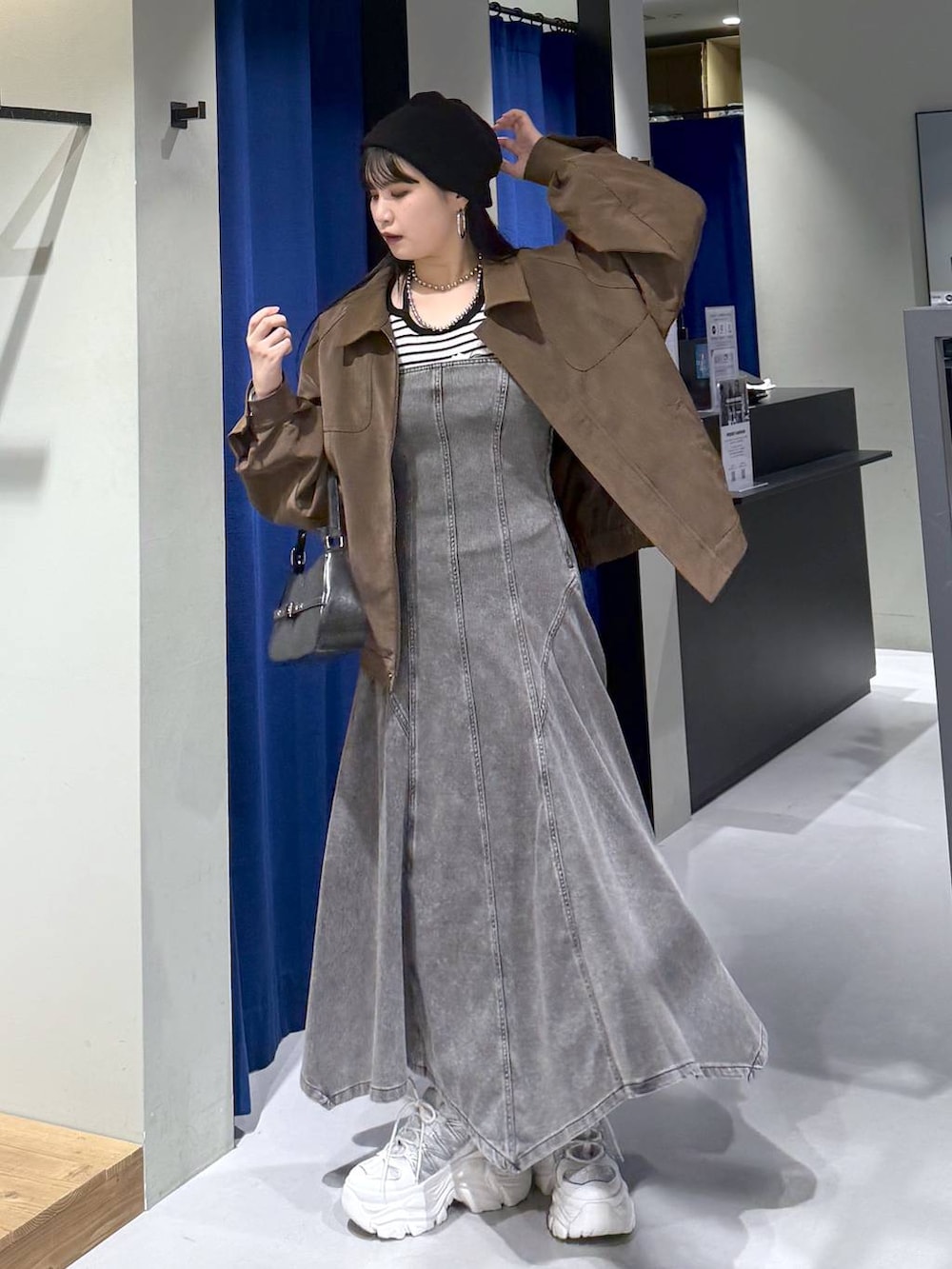 ホワイト系のスニーカー、ブラック系のハンドバッグ、ホワイト系のニット/セーターを着用したレディースの春コーディネートの7枚目の写真