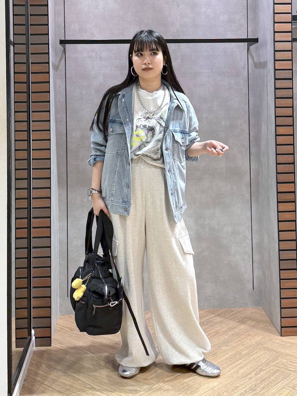 ブラック系のボストンバッグ、ブルー系のブルゾン、ベージュ系のその他パンツを着用したレディースの春コーディネートの2枚目の写真