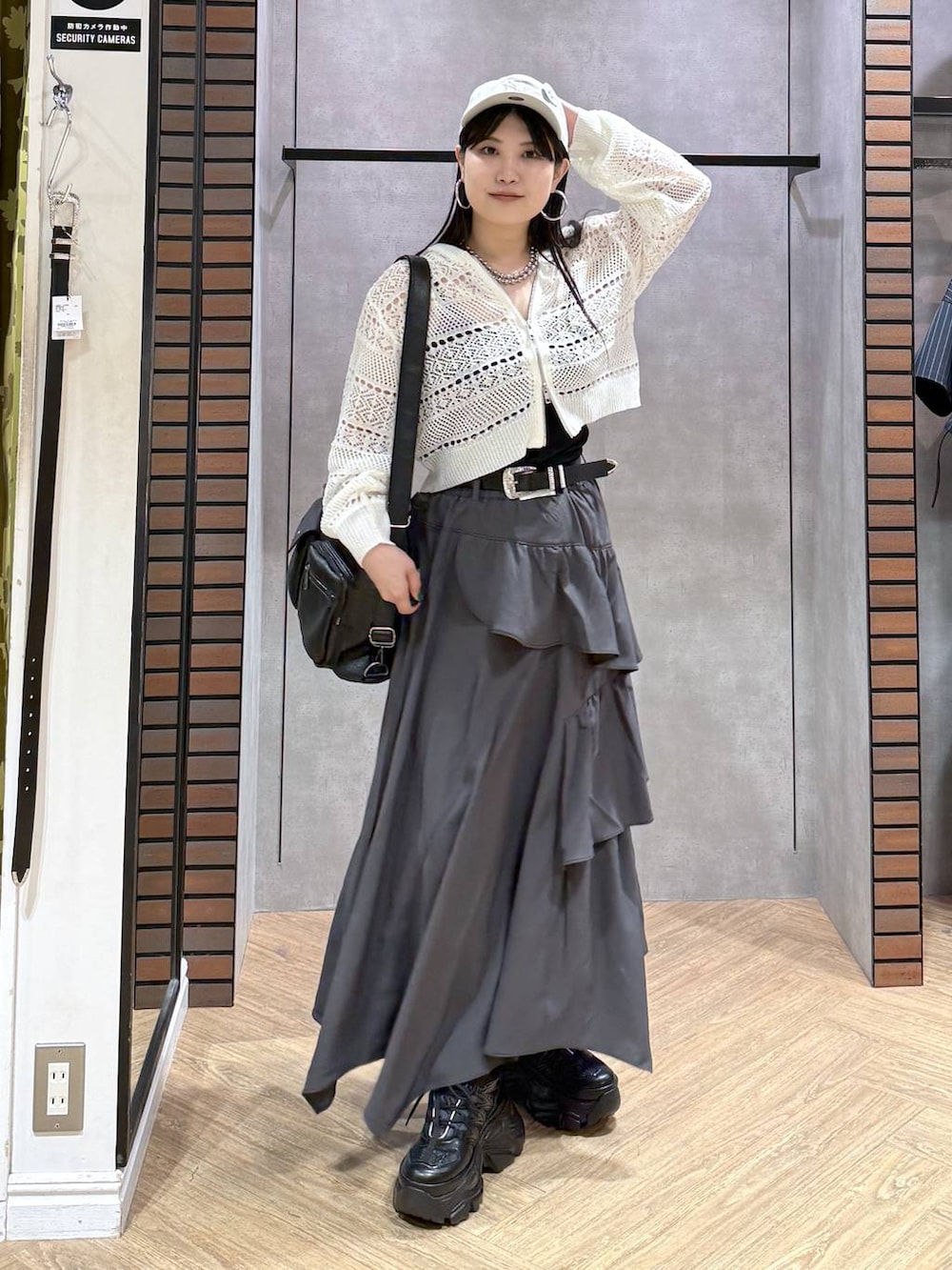 グレー系のスカート、ブラック系のスニーカー、ホワイト系のパーカーを着用したレディースの夏コーディネートの5枚目の写真