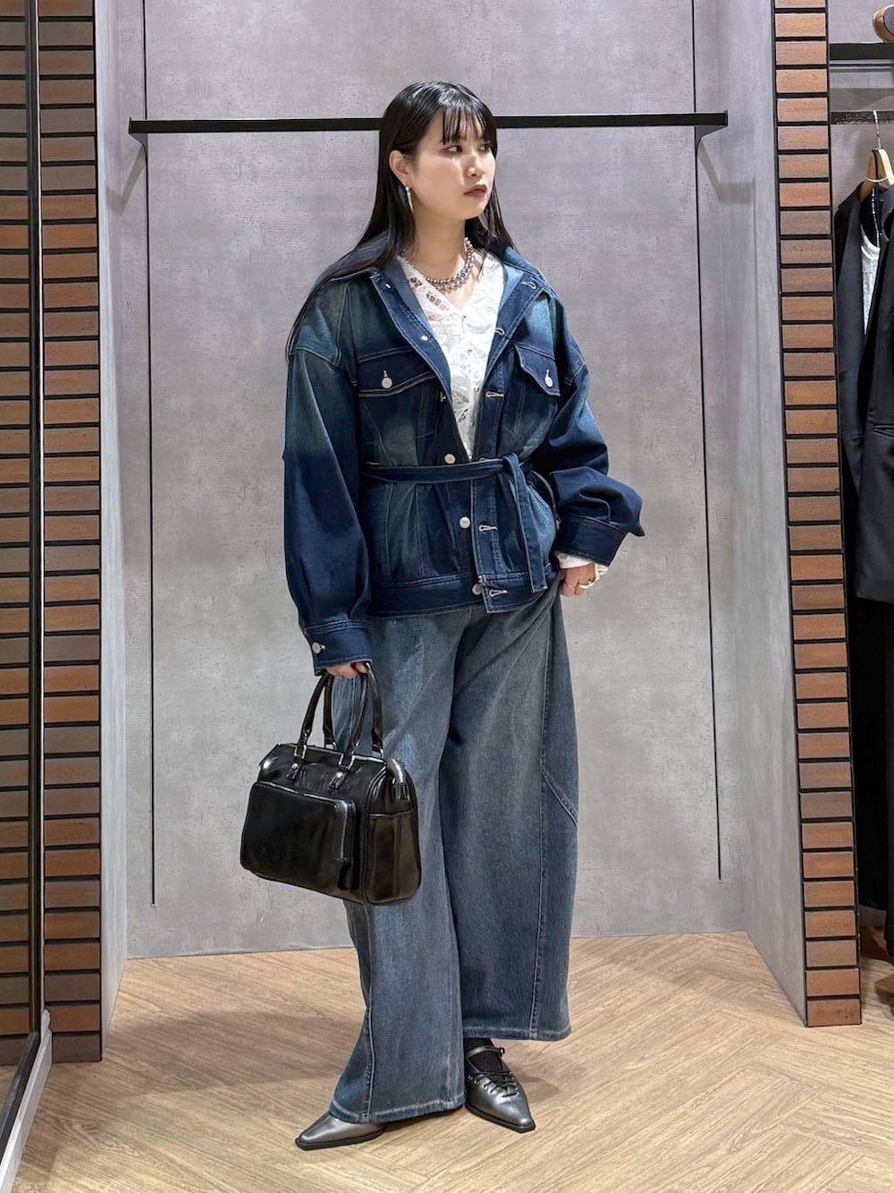 ブルー系のブルゾン、グレー系のショルダーバッグ、ホワイト系のタンクトップを着用したレディースの春コーディネートの6枚目の写真