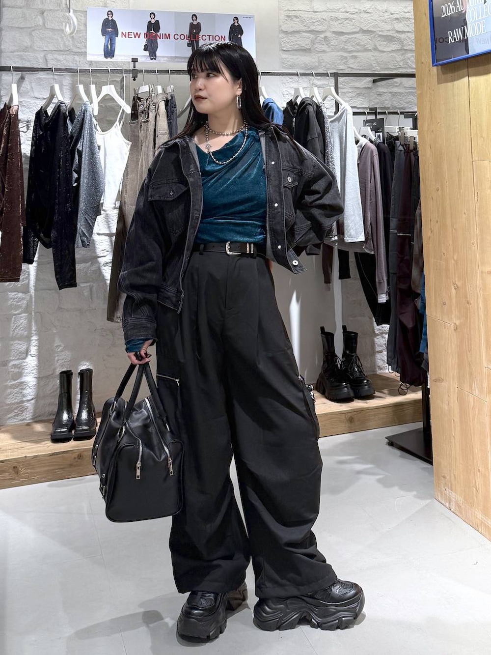 ブラック系のカーゴパンツ、ブラック系のデニムジャケット、ブラック系のスニーカーを着用したレディースの秋コーディネートの5枚目の写真