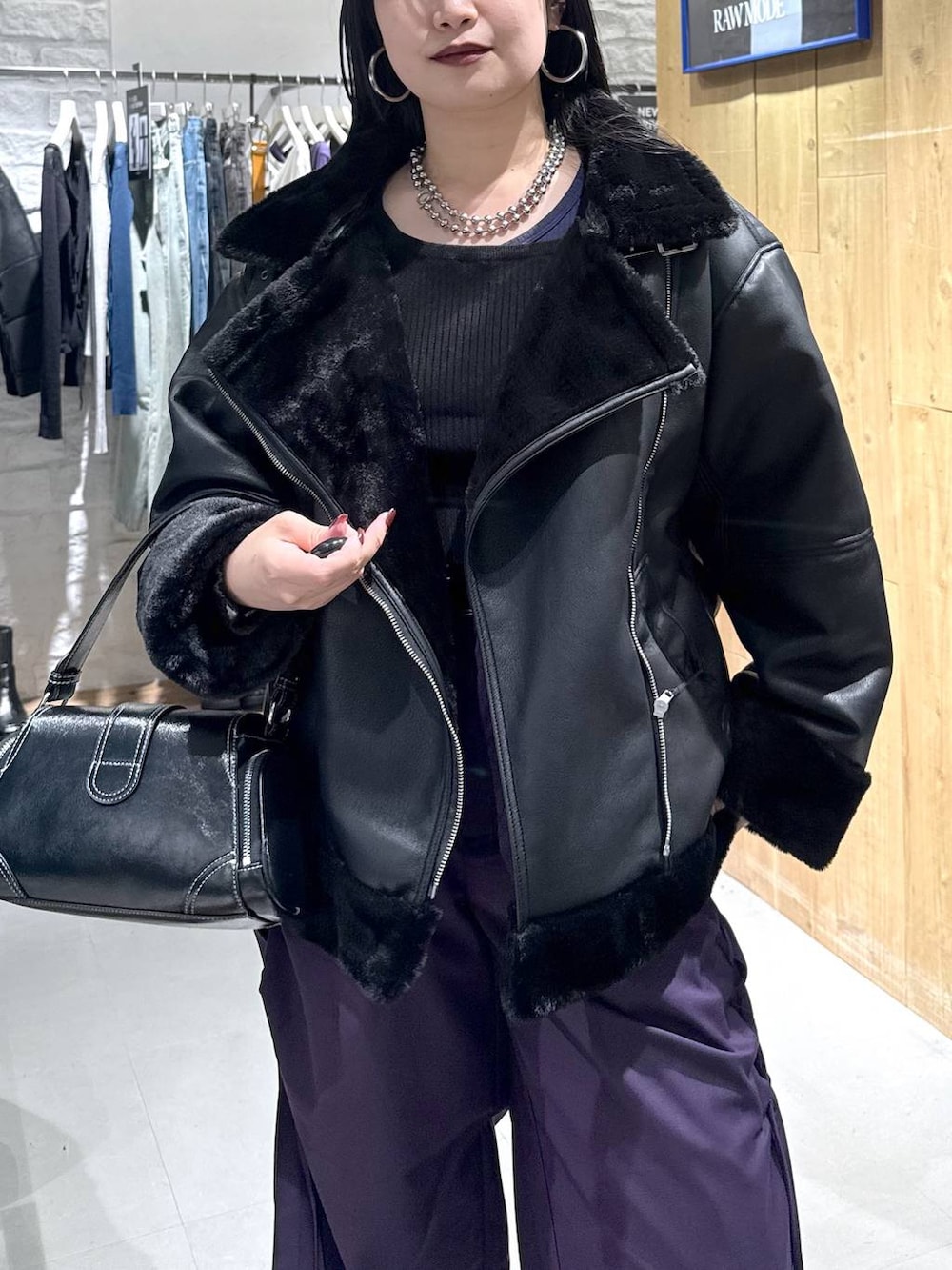 ブラック系のライダースジャケット、パープル系のその他パンツ、ブラック系のショルダーバッグを着用したレディースの秋コーディネートの2枚目の写真